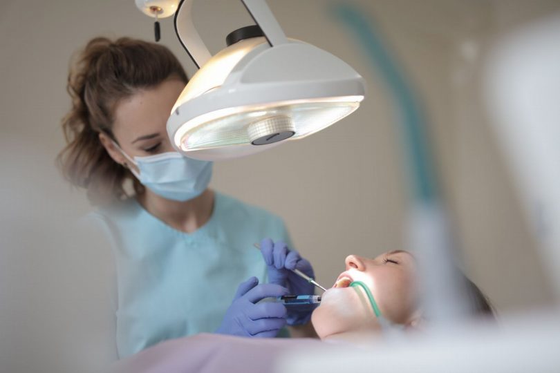 Dentista orientando paciente em consultório odontológico na Vila Mariana