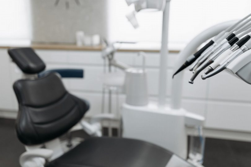 Dentista em consultório odontológico na Vila Mariana avaliando paciente e analisando radiografia