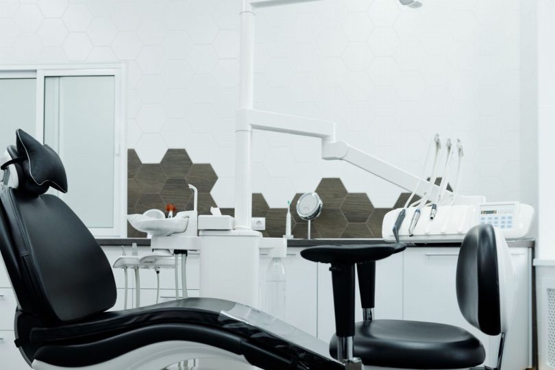 Dentista atendendo paciente em consultório odontológico moderno na Vila Mariana
