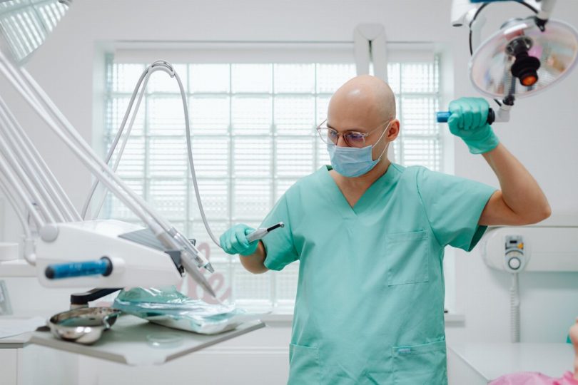 Dentista para cirurgia oral analisando exame de tomografia antes do procedimento