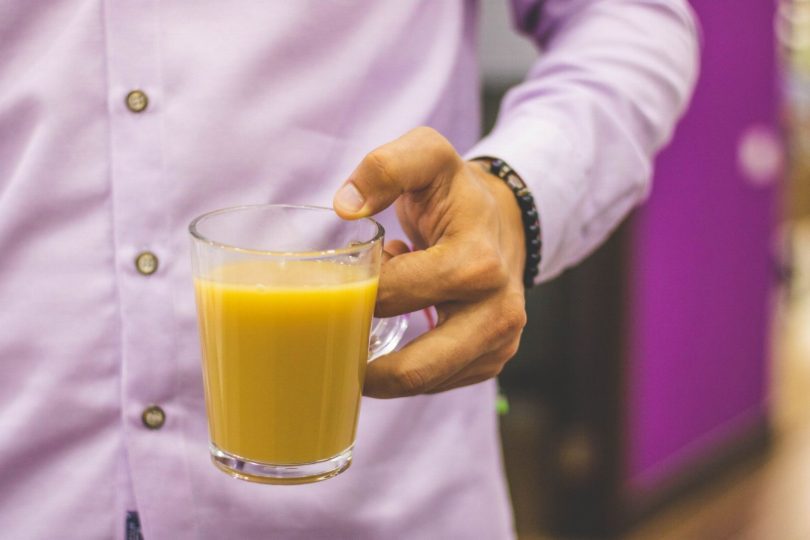 Paciente com lentes de contato dental segurando xícara de café e taça de vinho