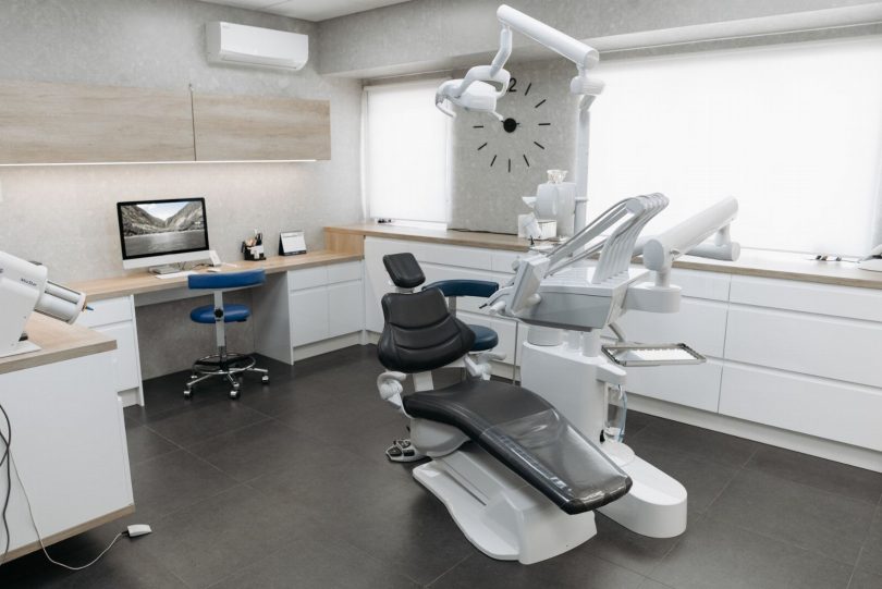Dentista em consultório moderno avaliando exame e planejando tratamento odontológico na Vila Mariana