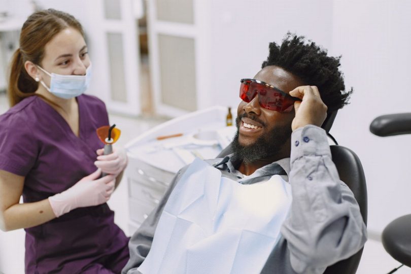 Paciente segurando um alinhador invisível durante consulta em clínica odontológica