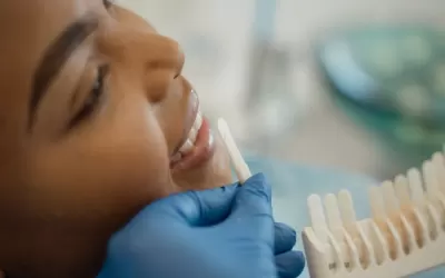 Dentista avaliando dentes anteriores para lente de contato dental com instrumentais clínicos