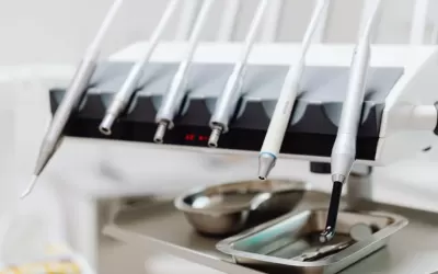 Dentista atendendo paciente em consultório odontológico na Vila Mariana com EPI e ambiente clínico moderno