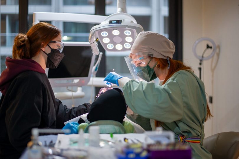 Dentista em consultório na Vila Mariana analisando tomografia para planejar tratamento odontológico